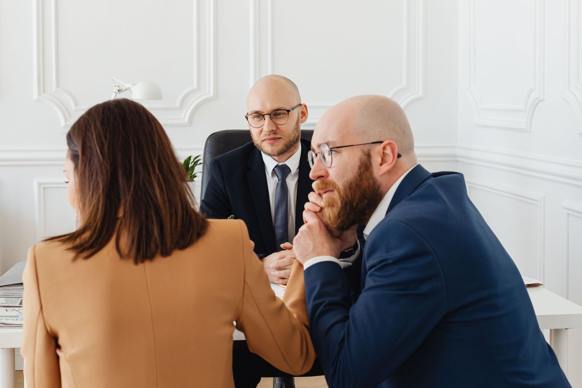 Three business professionals having a serious discussion during an office meeting.