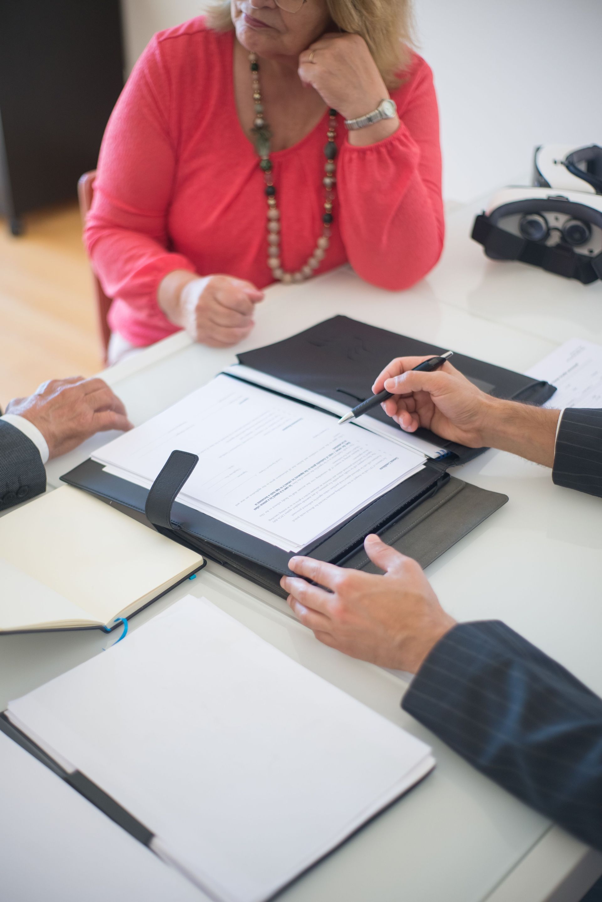 A close-up of hands reviewing and pointing at paperwork on a desk.