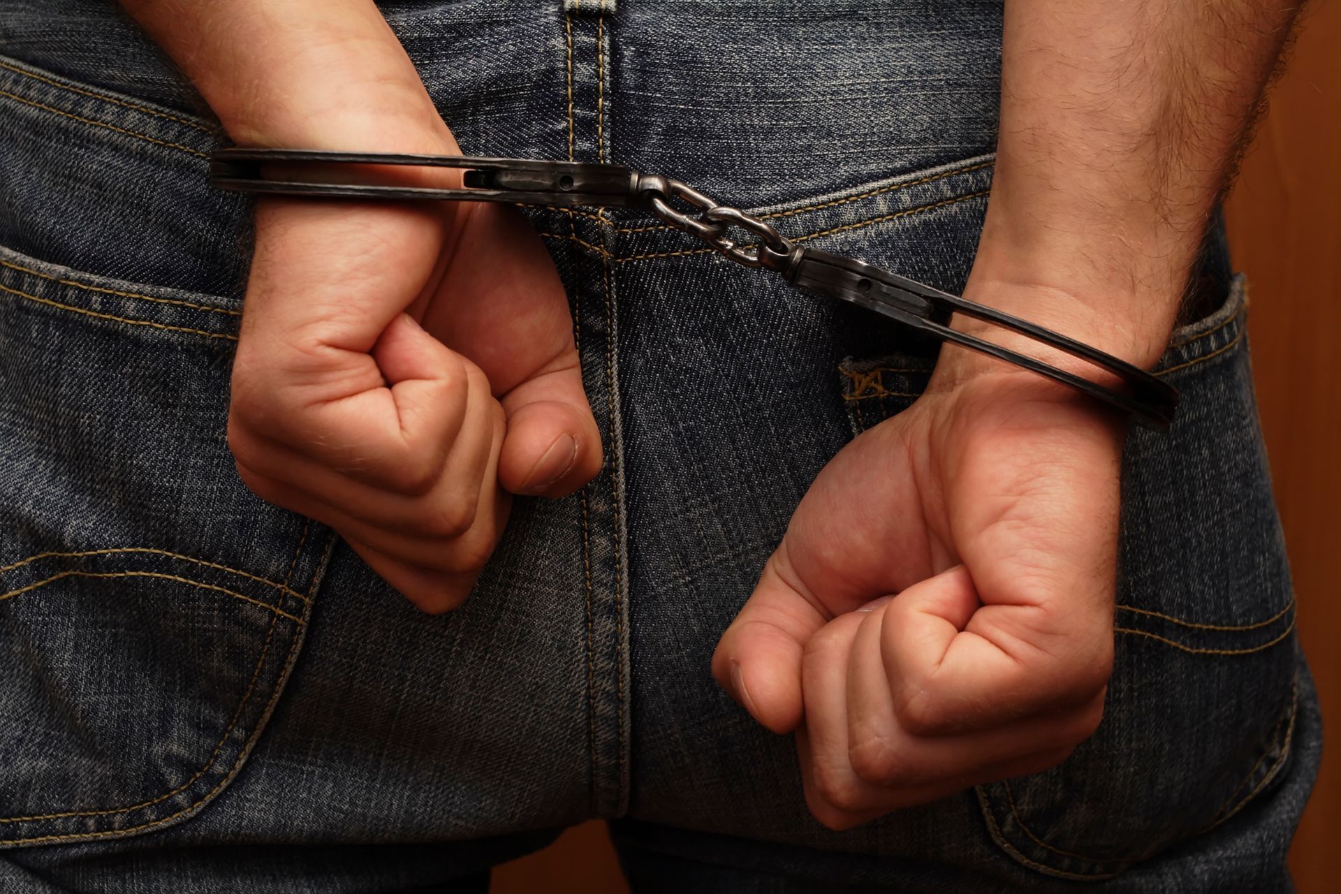 Person in handcuffs representing arrest, relevant to a criminal DUI lawyer case.