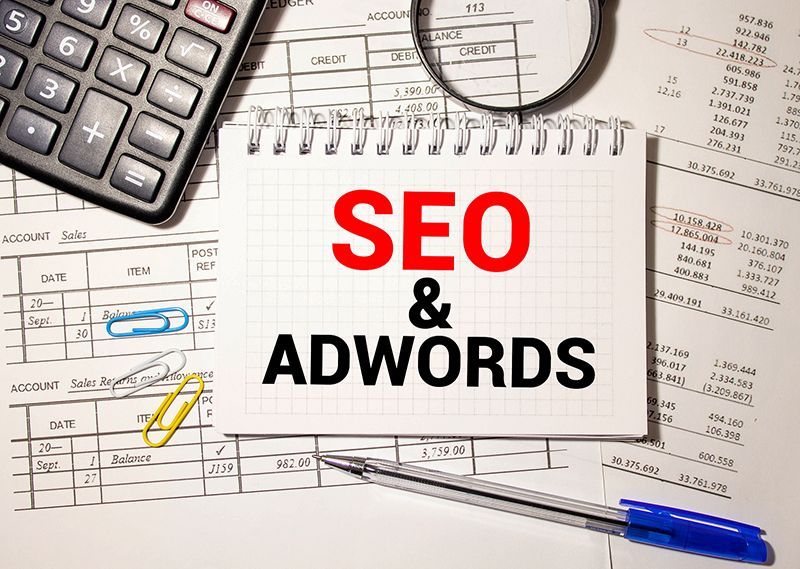 A notepad with the words seo and adwords written on it.