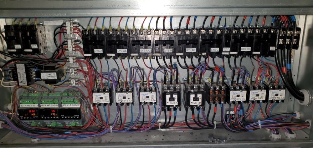 Electrical control panel with wires and components inside a metal box.