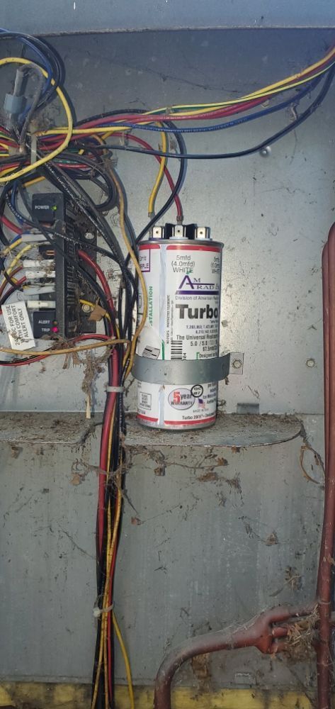 Air conditioner capacitor and wiring inside of metal housing.