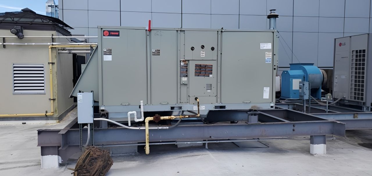 HVAC equipment on a rooftop under a clear blue sky.