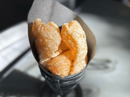 Crispy Cajun-seasoned pork rinds served in a paper cone