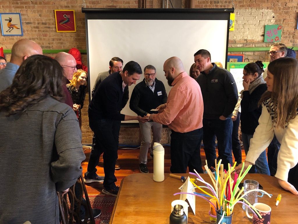 People gathered around a table for a hands-on demonstration in a classroom.