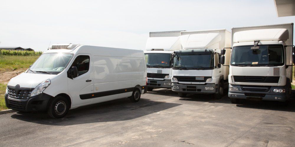 A Row of White Vans and Trucks Are Parked — All Care Car Services Kumho Tyre Platinum Dealer in Kurri Kurri, NSW