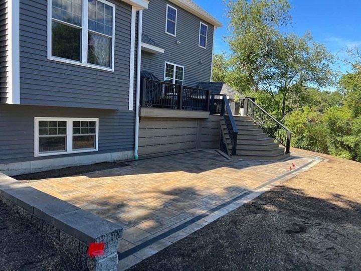 New custom patio installed. Two tiered with new deck, retaining wall, and steps.