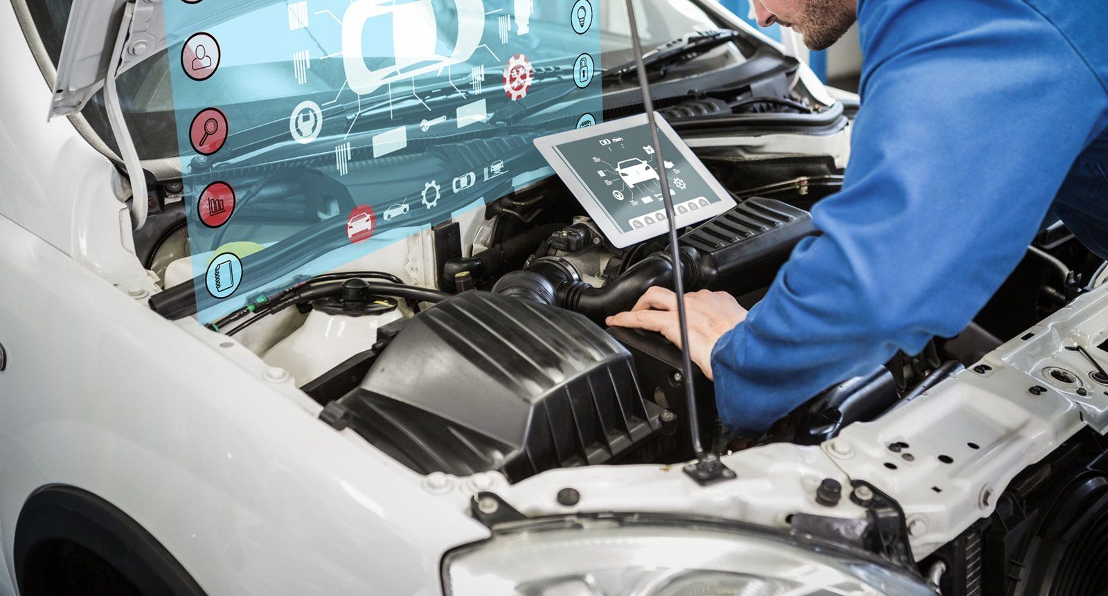 A man is working on a car with a laptop.