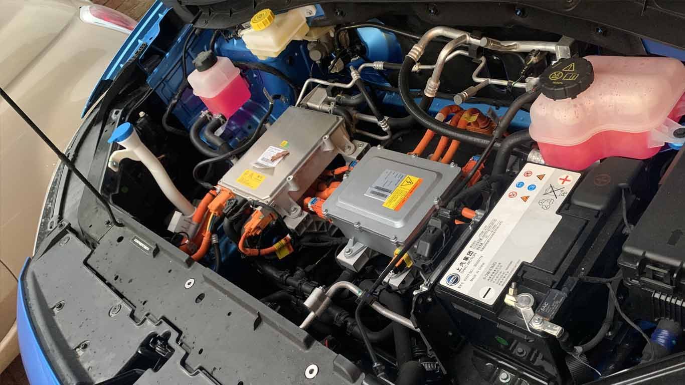 A close up of the engine of a car with the bonet open.