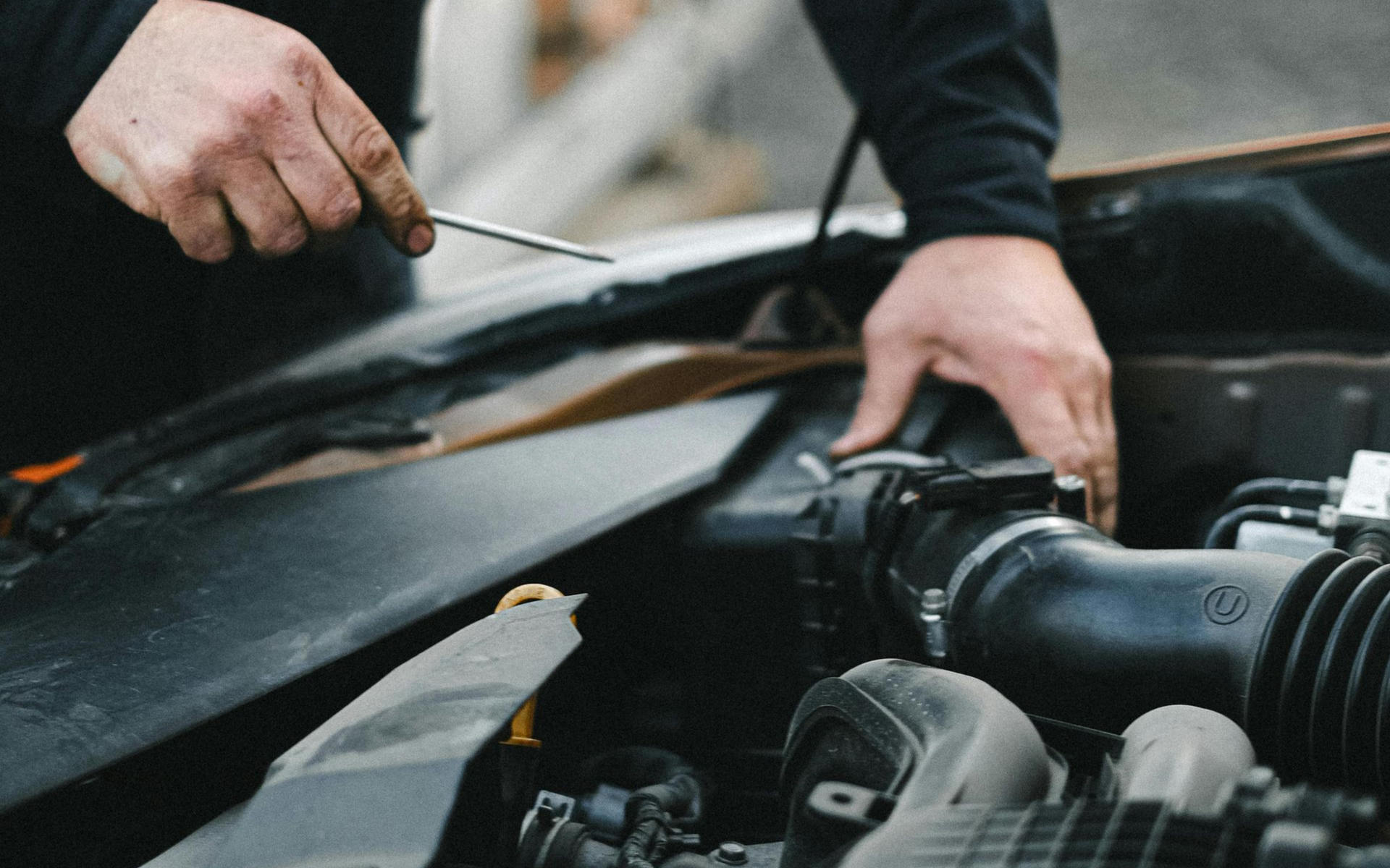car mechanic looking at car engine