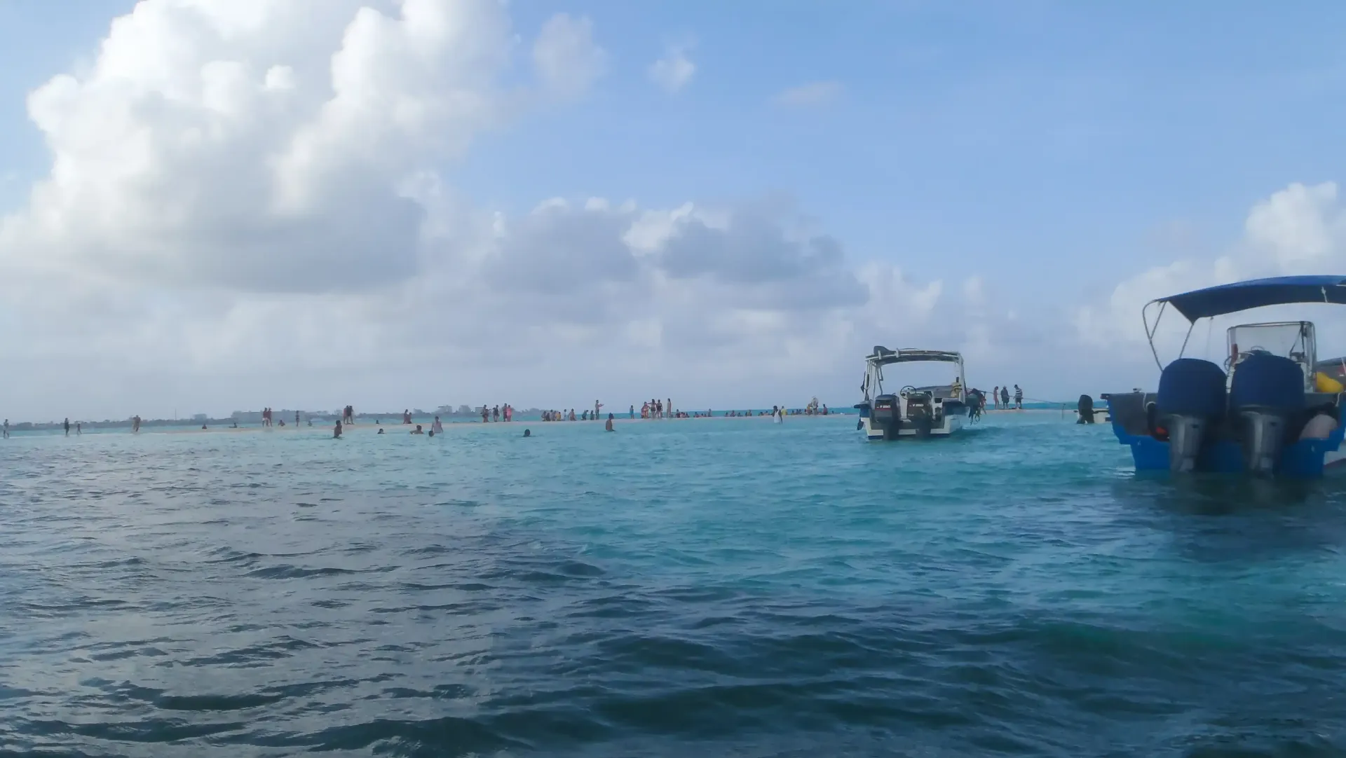 Playa en San Andrés con mar turquesa, palmeras y turistas disfrutando el destino caribeño.