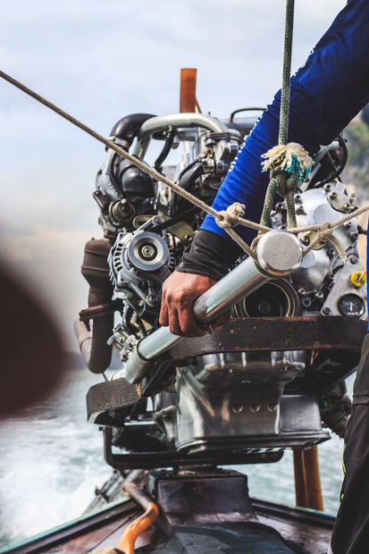 Person steering a rope-lift machine, hands on gears and cables in a misty outdoor setting