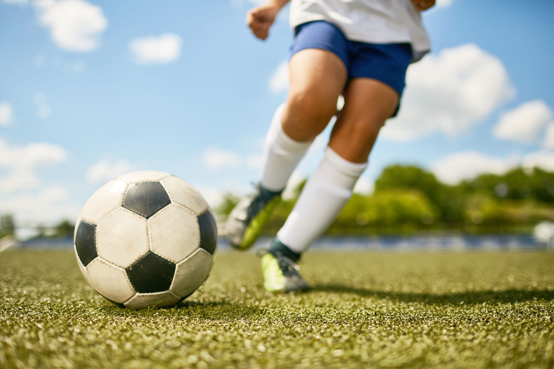 Child kicking a soccer ball on the grass