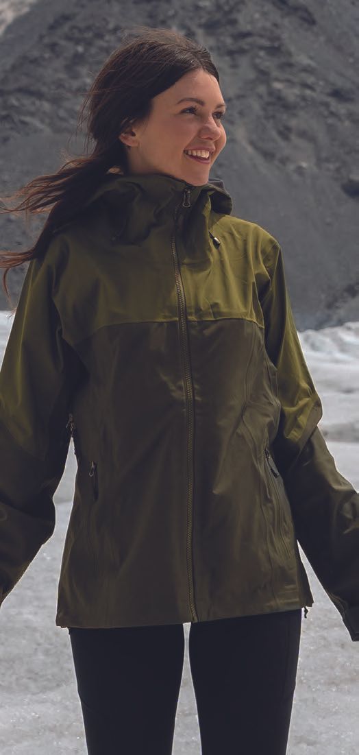Μια γυναίκα που φοράει ένα πράσινο μπουφάν North Face στέκεται στο χιόνι.
