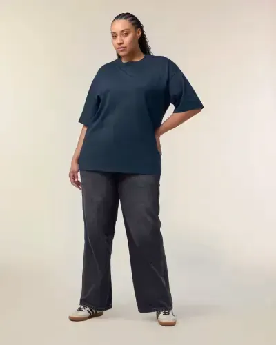 Ένα μοντέλο plus size φοράει ένα μπλε μπλουζάκι και μαύρο τζιν.