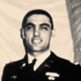 A man in a military uniform is standing in front of a red and white flag. Michael Locascio, 1st Lieutenant, United States Army
(1940 - 2024), Fairview Cemetery Westfield, NJ