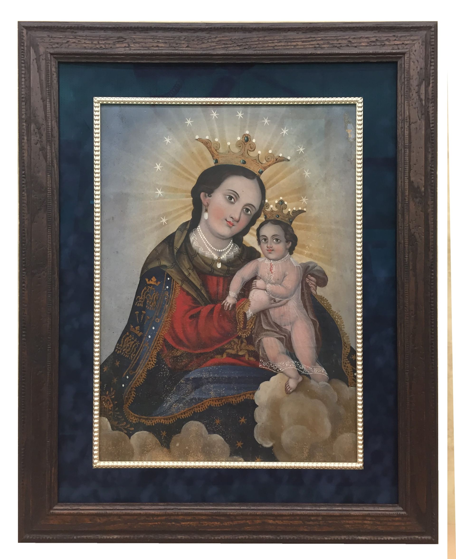 Painting of Virgin Mary and child, both crowned. They are surrounded by a golden halo and cloud. Framed artwork.