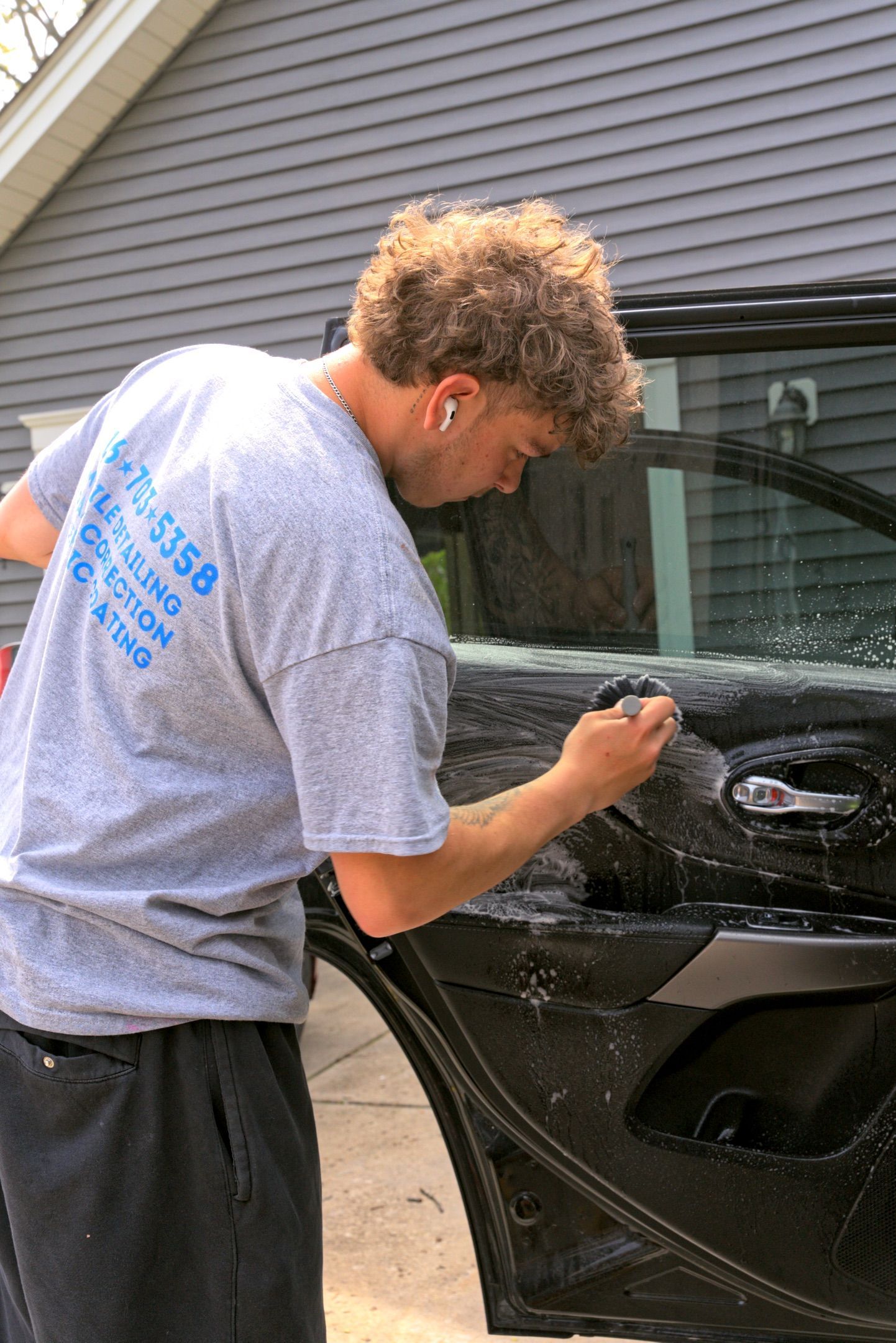 A person is cleaning the dashboard of a car with a cloth.