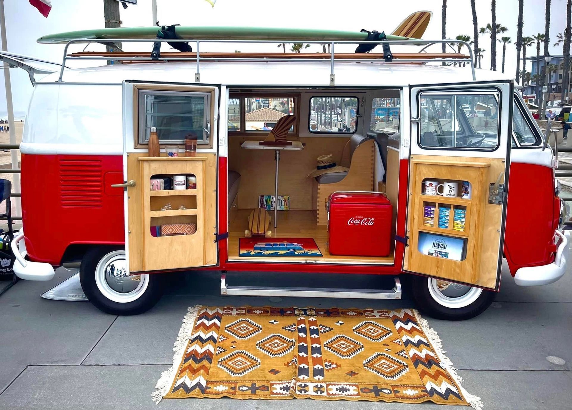 A red and white van with a surfboard on top of it