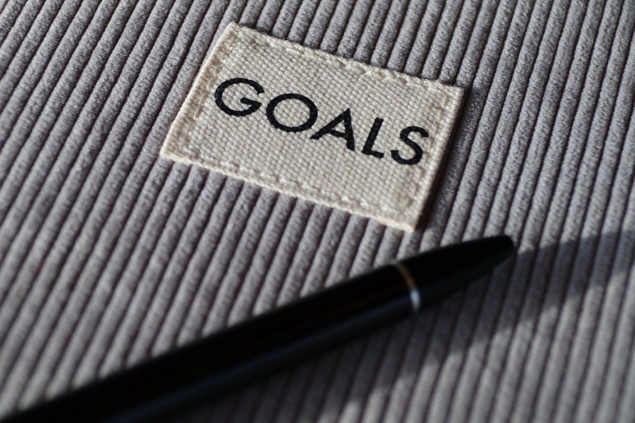 A pen is sitting on a piece of fabric with a label that says goals.