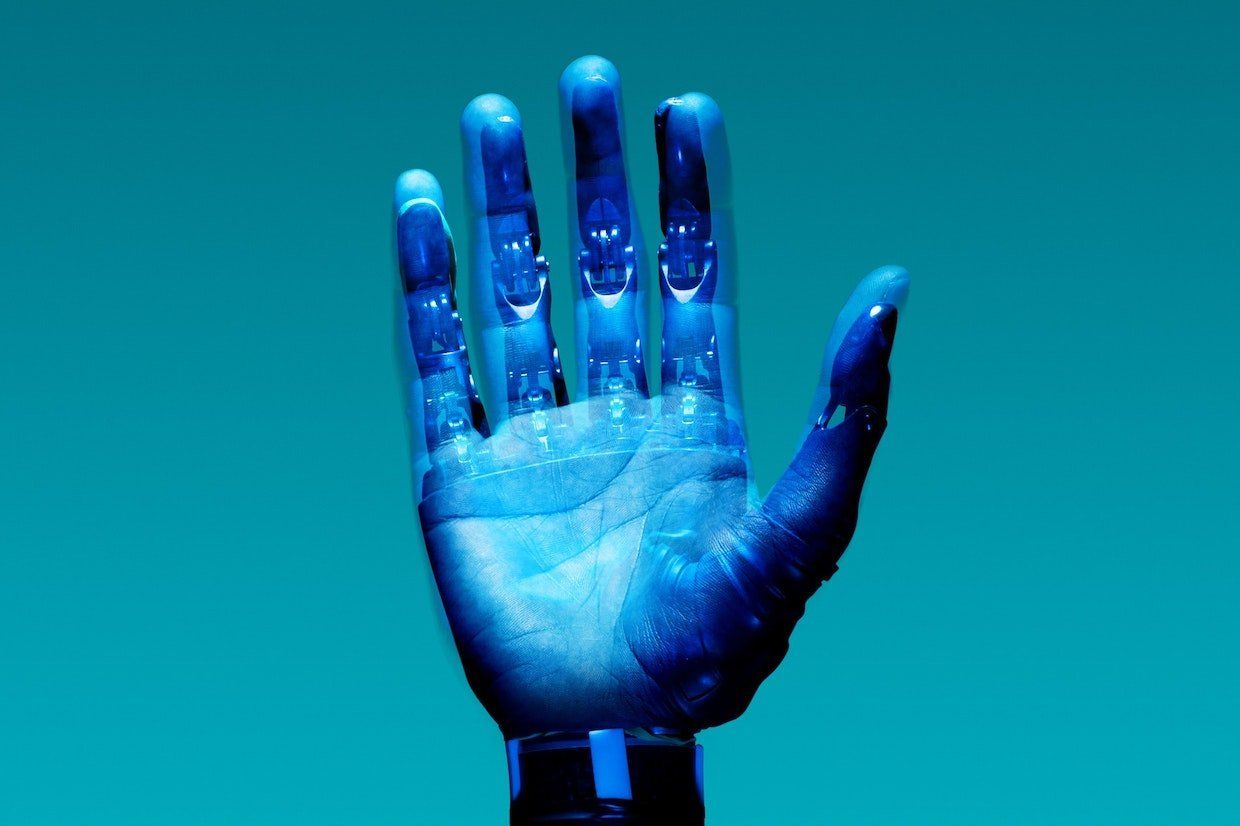 A close up of a blue hand on a blue background.
