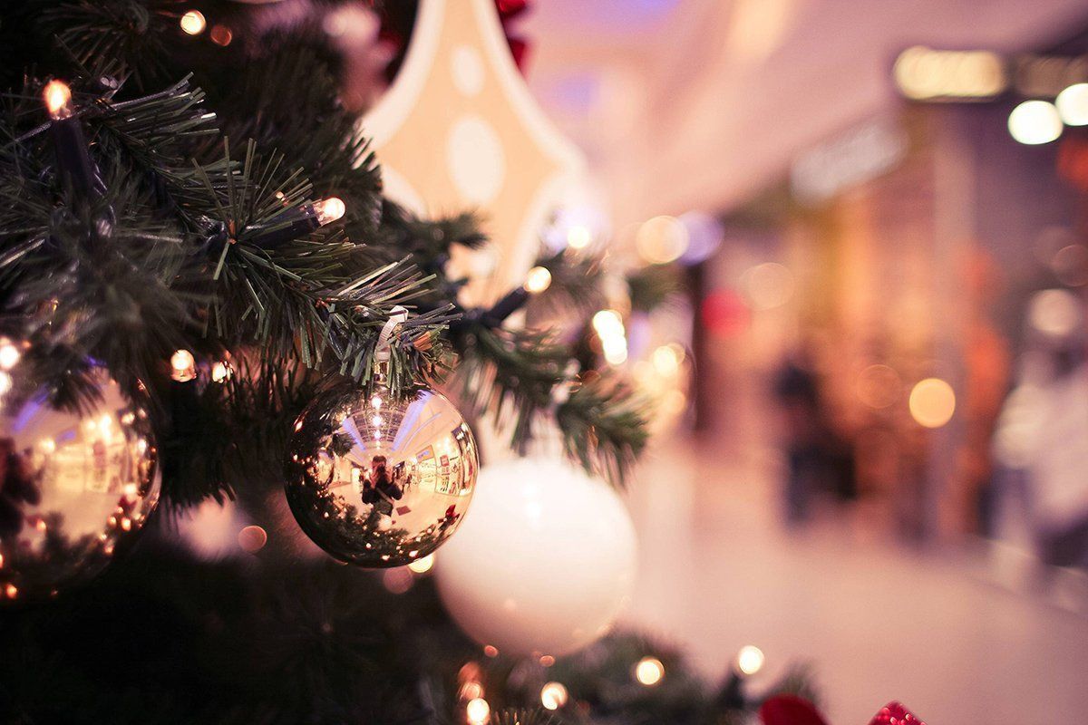 A close up of a christmas tree decorated with balls and lights.