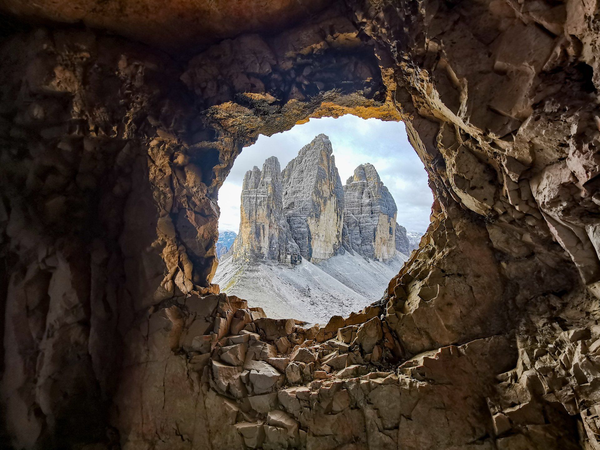A view of a mountain through a hole in the rocks.