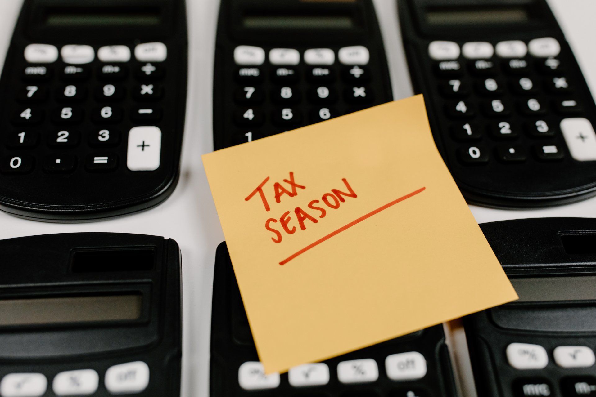 Several calculators with a sticky note that says tax season