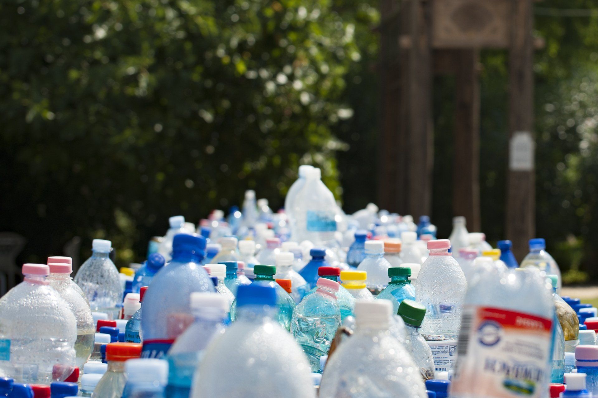 A bunch of plastic bottles are sitting on top of each other on a table.