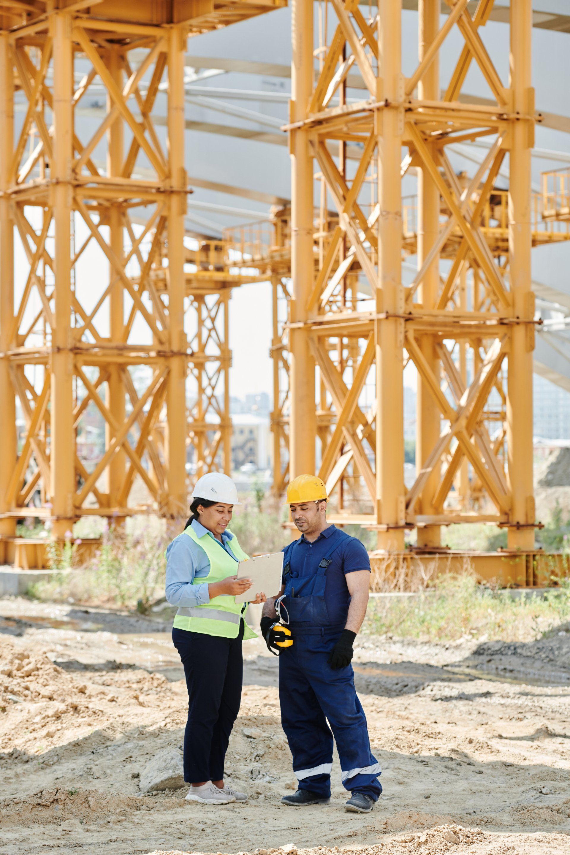 A man and a woman are standing next to each other on a construction site.