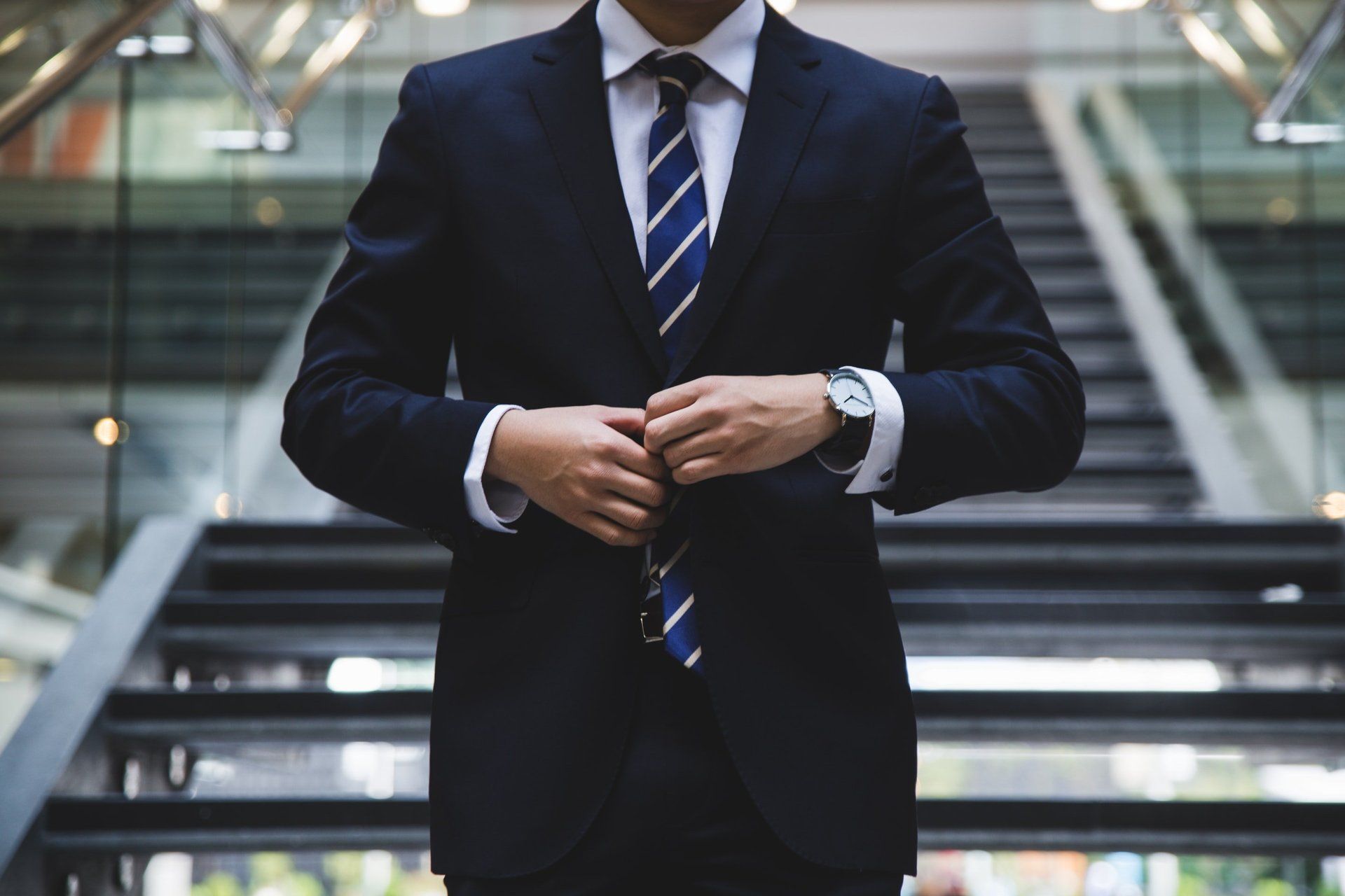 A man in a suit and tie is standing on a set of stairs.