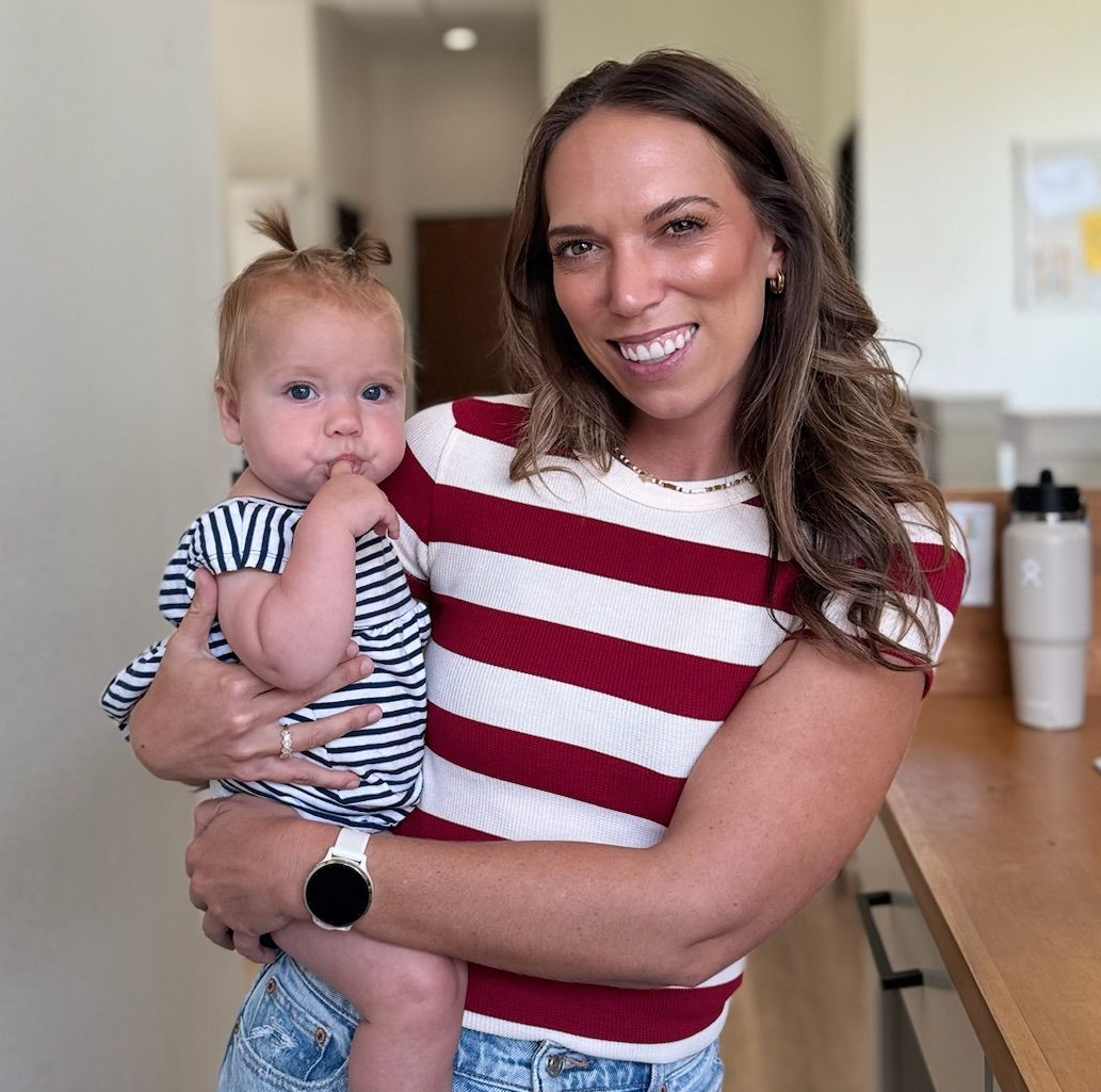 A woman smiling while holding a little girl in Living Water Chiropractic