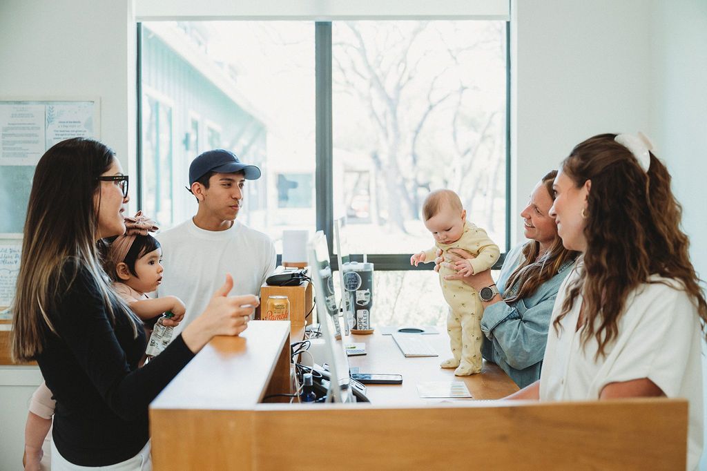 People chatting around a counter in Living Water Chiropractic with their children present