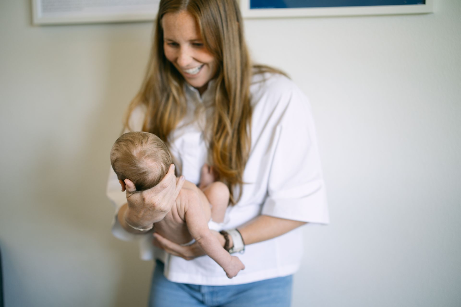 Dr. Ashley adjusting an infant in a light-filled room.