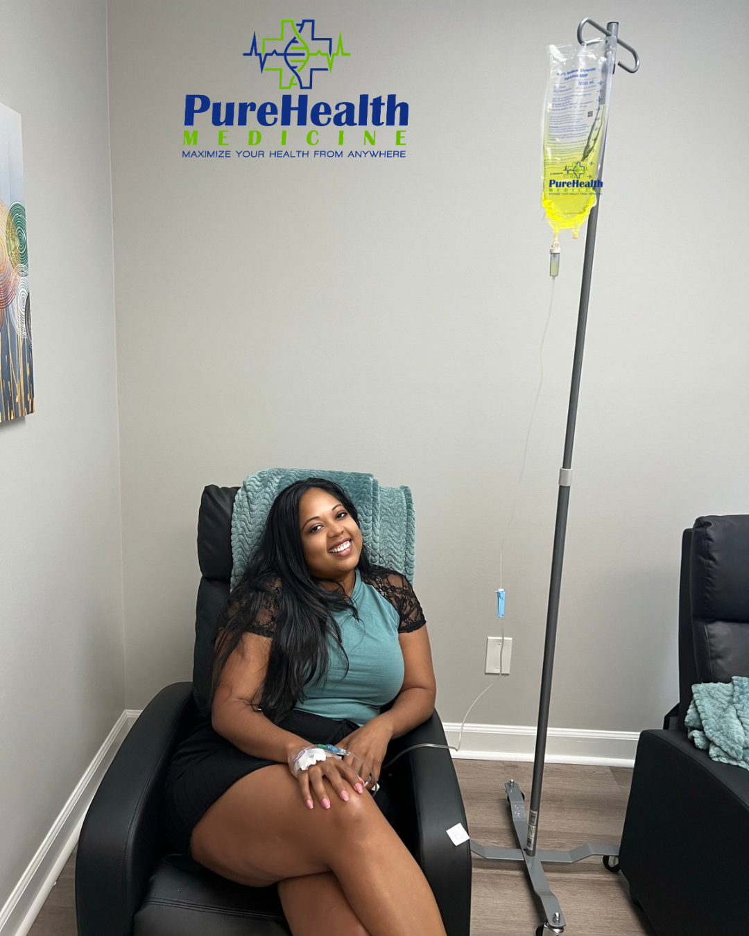 Woman seated in a clinic chair next to an IV stand, smiling in a medical office with Pure Health Wellness logo.