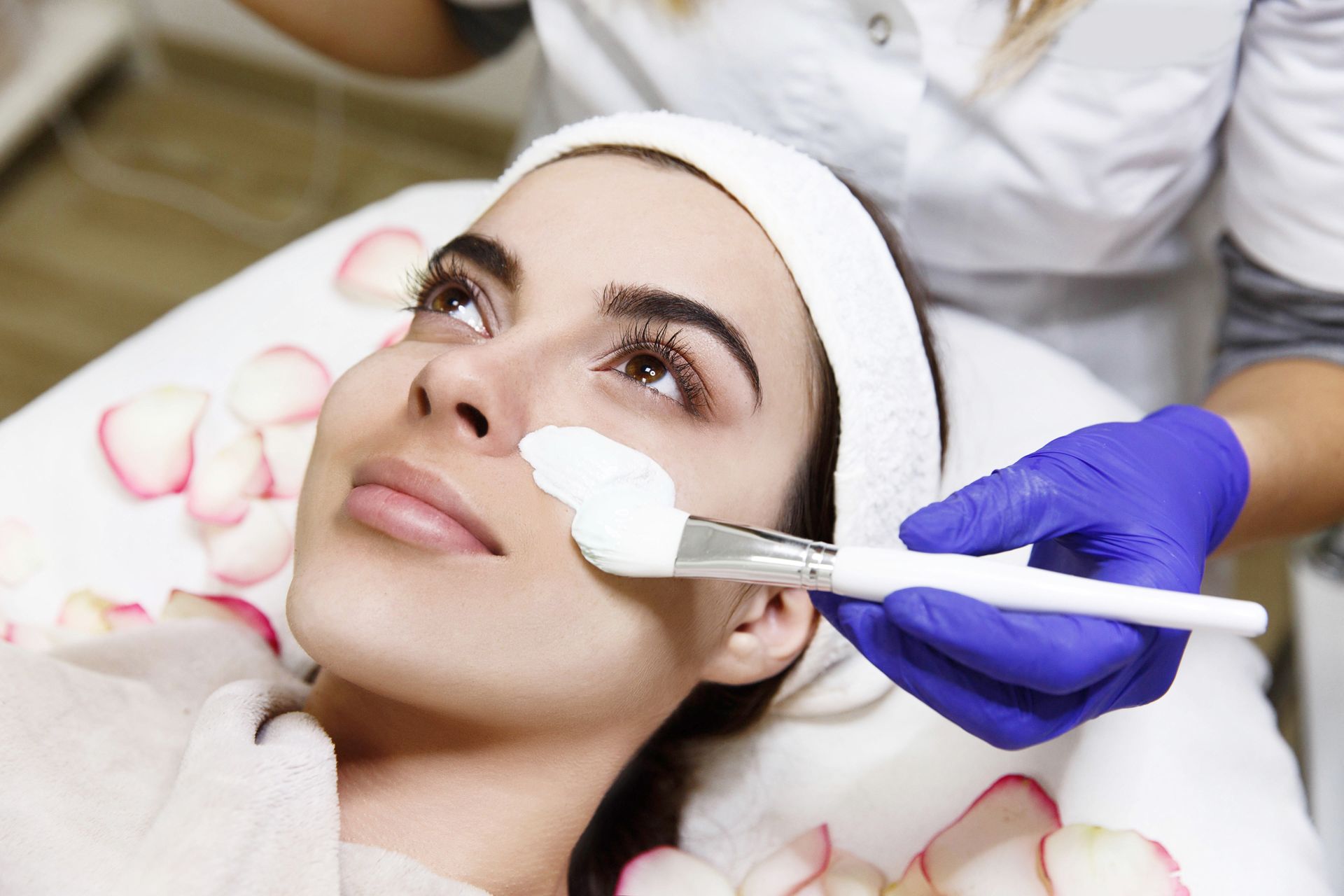 a woman getting a facial with a brush