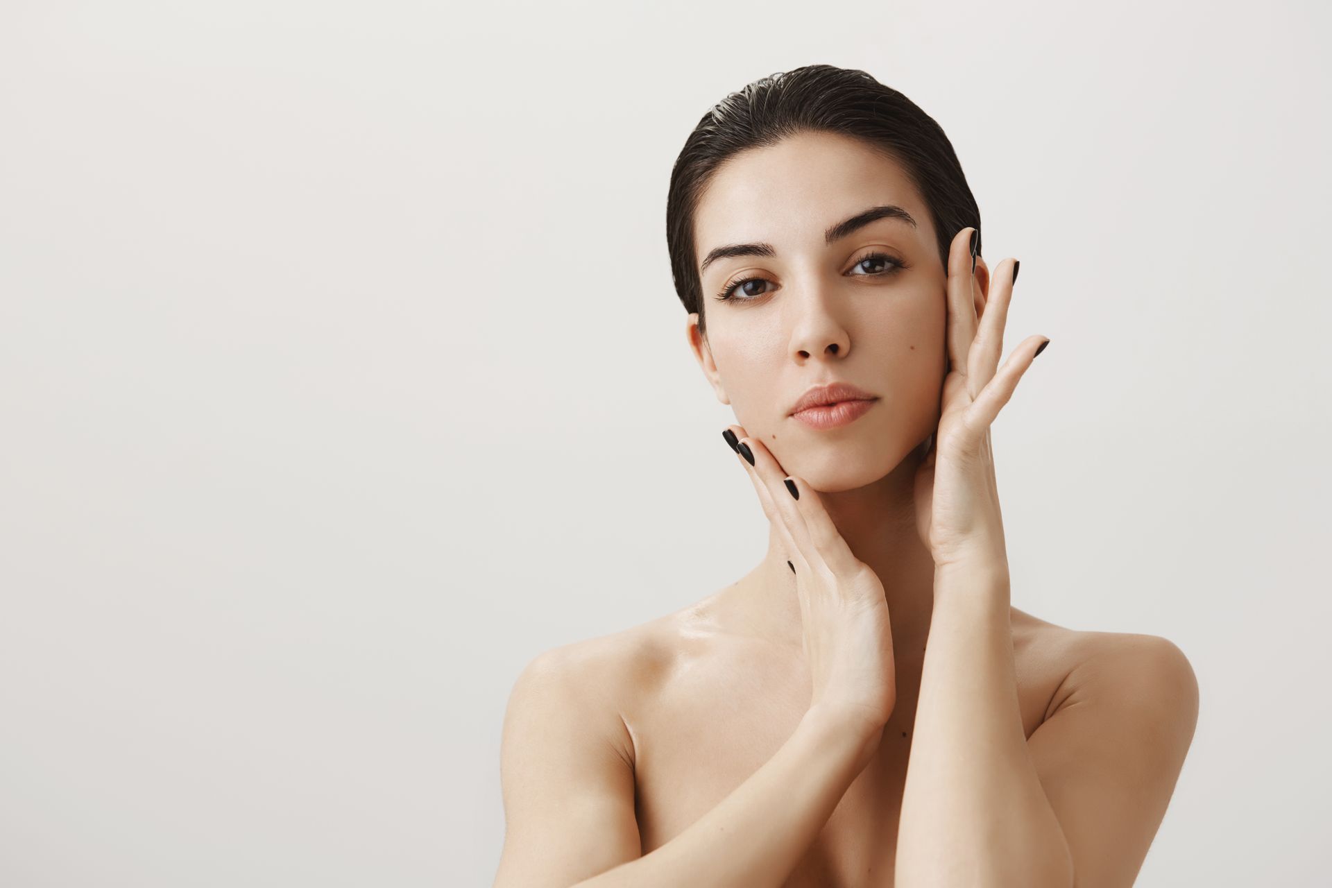 a woman looking at the camera and touching her face
