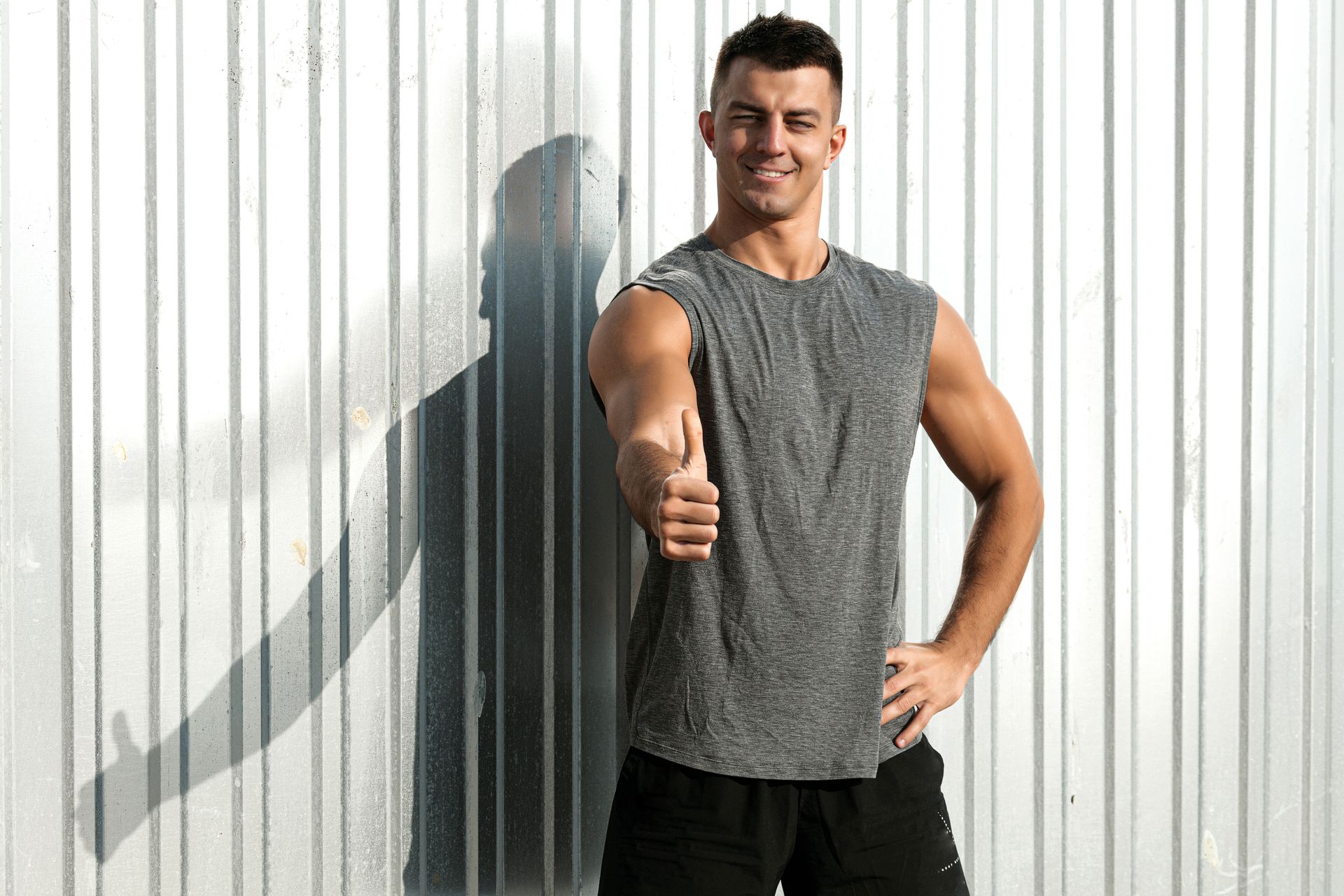 a man facing the camera with a thumbs up