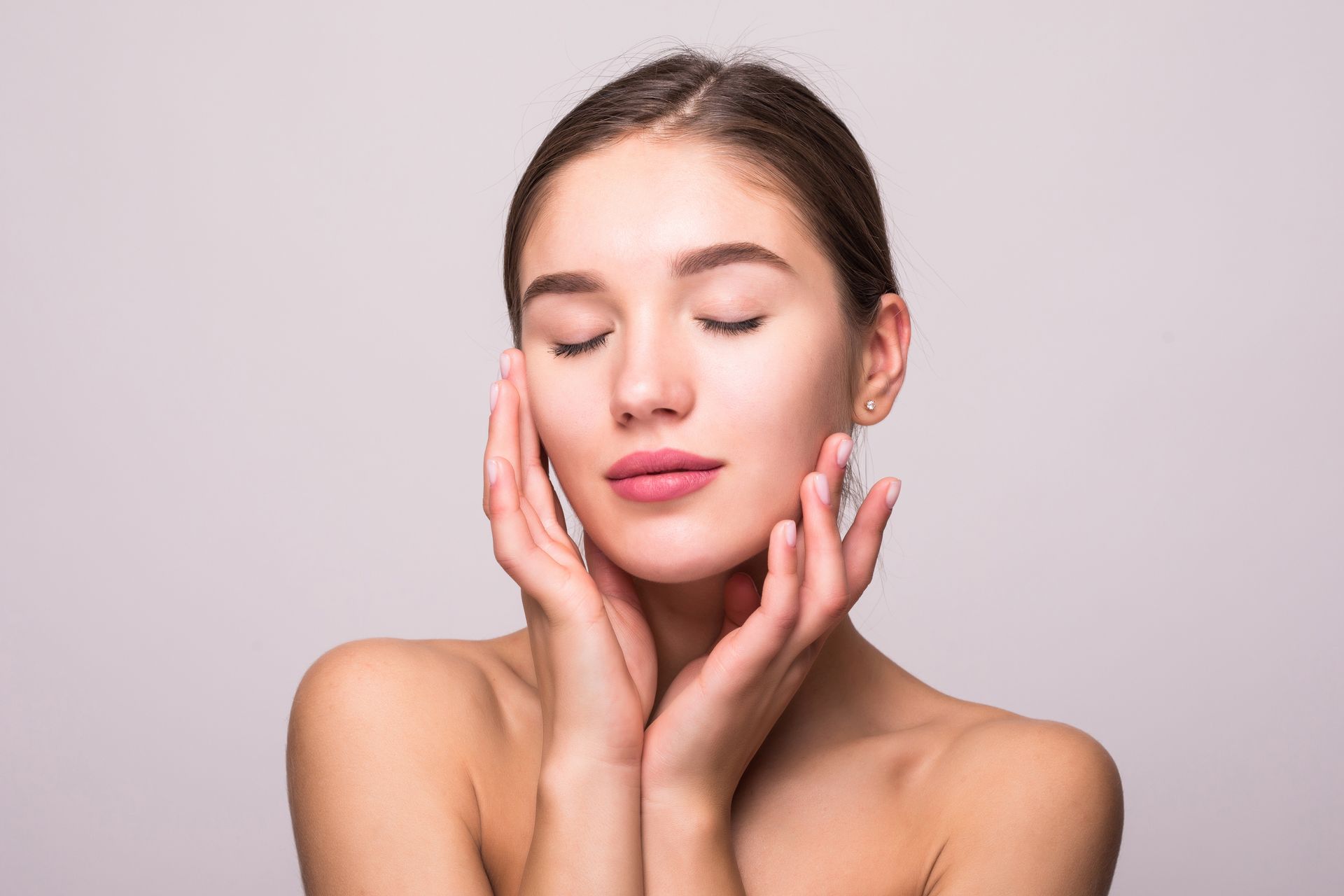 a woman with closed eyes, touching her face