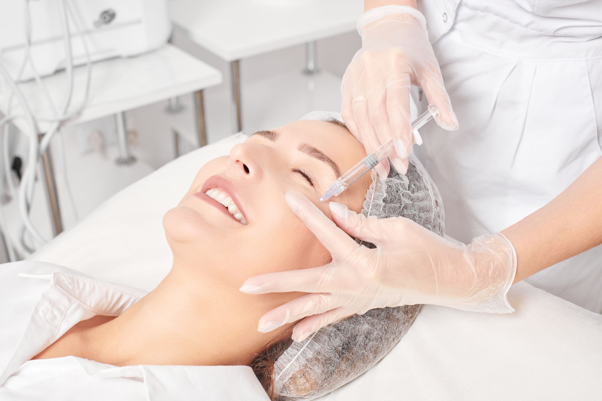 A facial treatment with a beautician massaging a woman's face in a spa setting