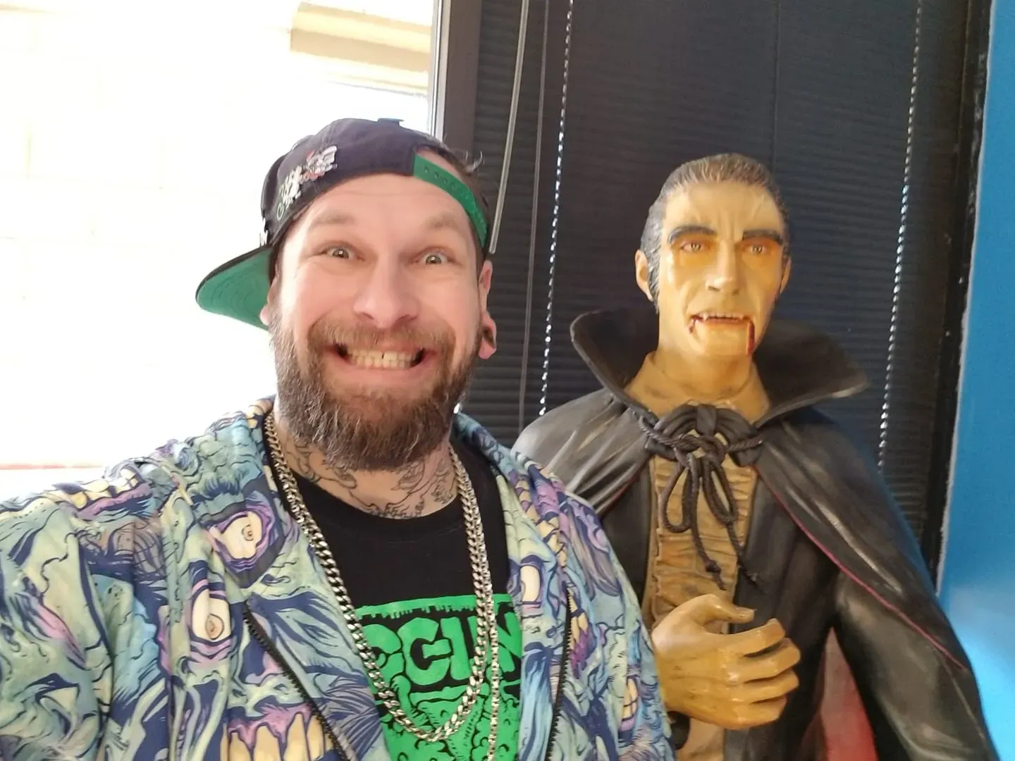 Brandon smiles next to a life-sized vampire statue.