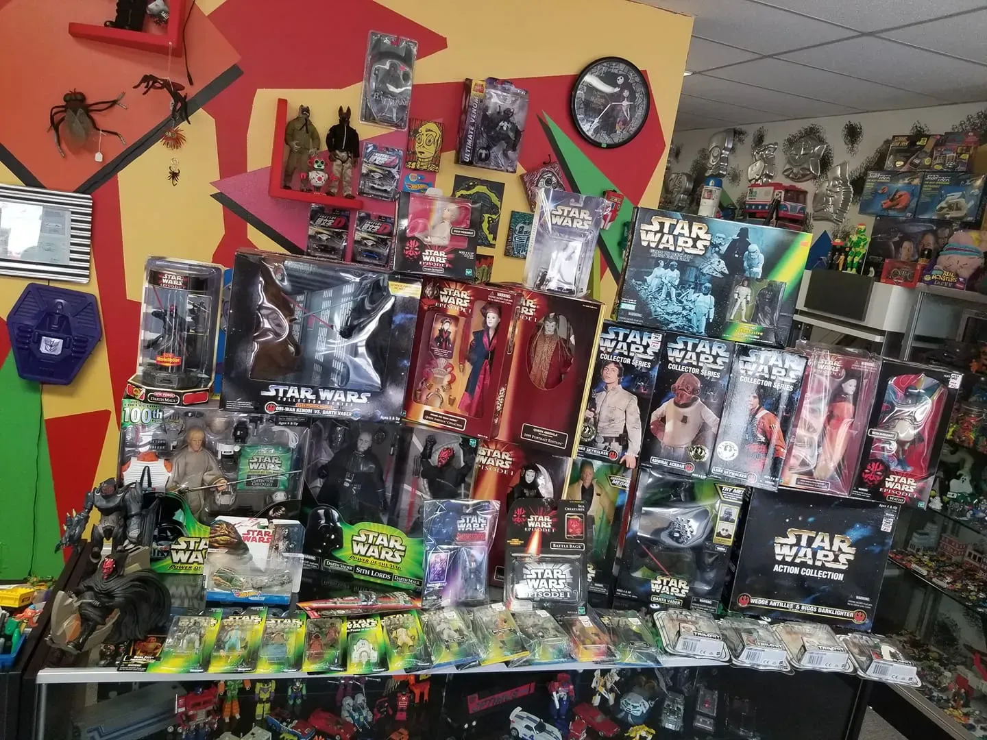 A display case inside a shop filled with a large collection of Star Wars action figures and packaged toys.