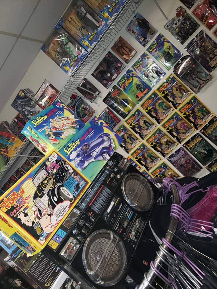 A shelf filled with boxed vintage action figures and a large, black boombox in the foreground.