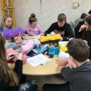 People gathered around a round table, working on projects.