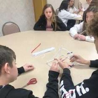 People at a round table working on a craft project.