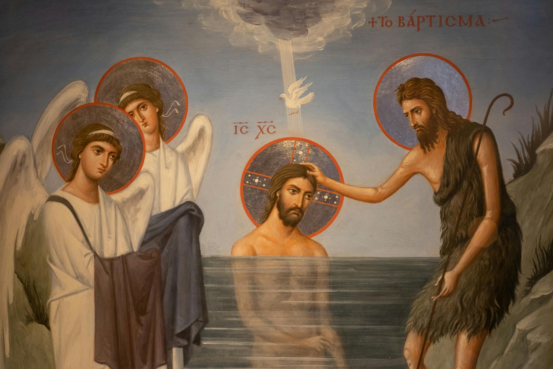 Jesus being baptized by John, with angels, dove, and halo.