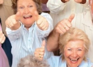 Group of smiling people giving thumbs up.