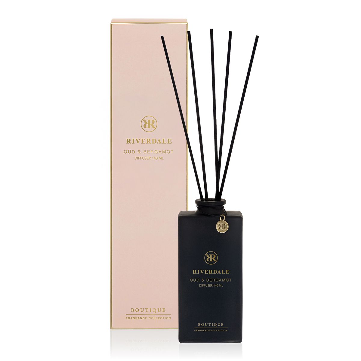 Roze en zwarte rietdiffuserset met een hoge doos en een flesje met zwarte rietjes.