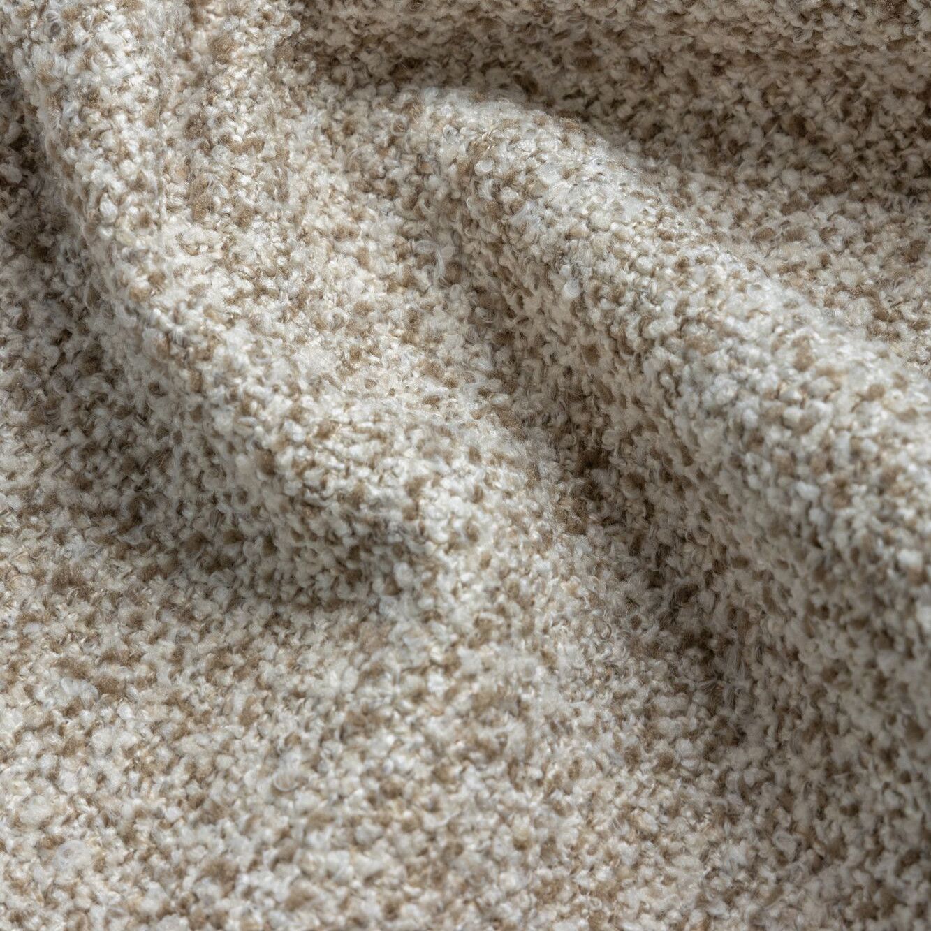 Detailopname van een beige en bruine, gestructureerde stof met zachte plooien en schaduwen.