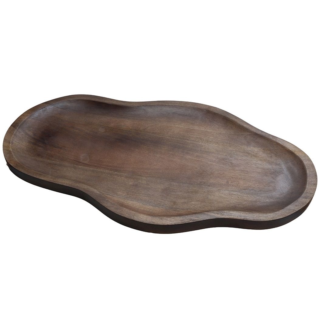 Witte bloesem in donkere glazen vazen op een houten dienblad in een moderne woonkamer.
